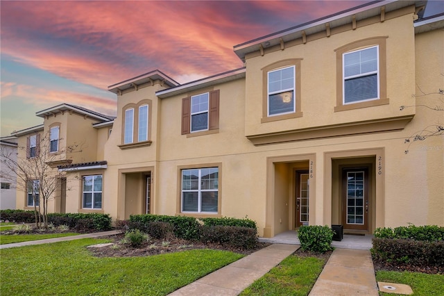 multi unit property featuring a yard and stucco siding