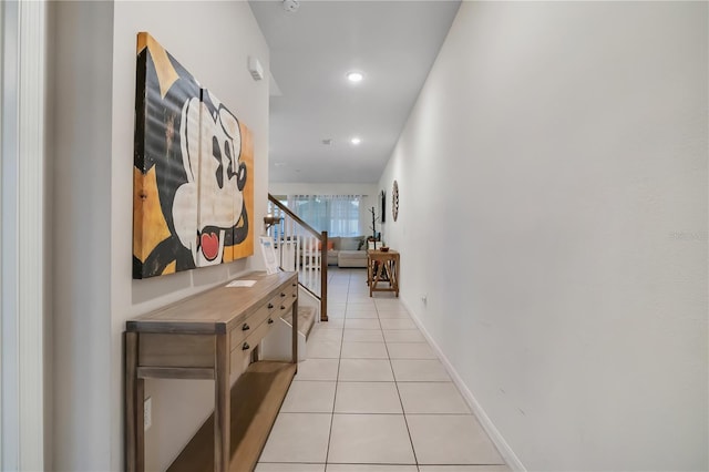 corridor featuring stairs, recessed lighting, baseboards, and light tile patterned floors