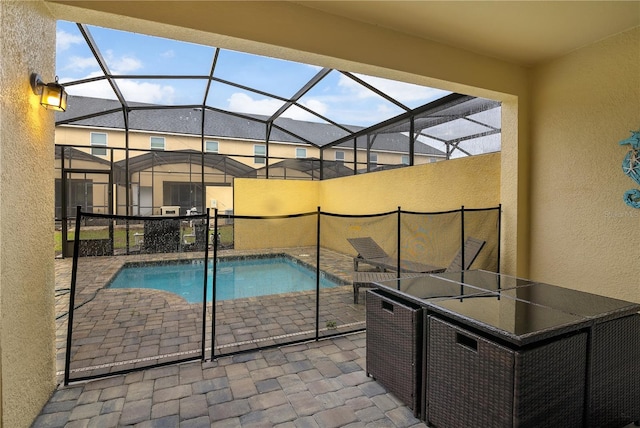 pool with a patio and glass enclosure