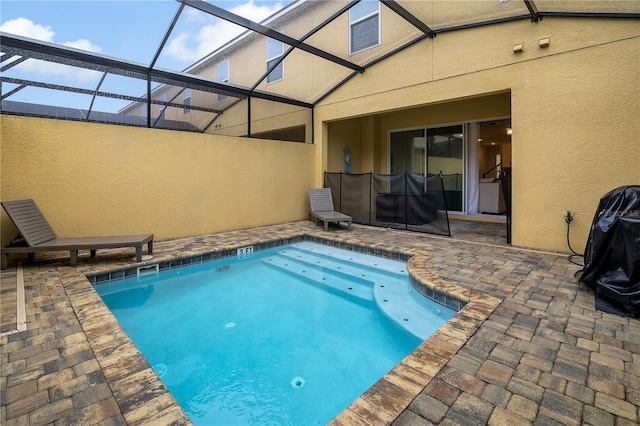 view of pool with a patio and glass enclosure