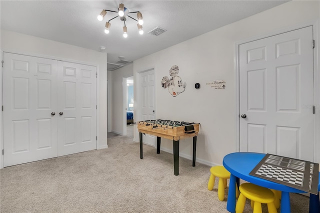 recreation room featuring light carpet, visible vents, and baseboards