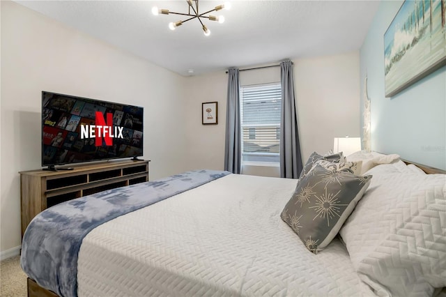 bedroom with carpet, baseboards, and a notable chandelier