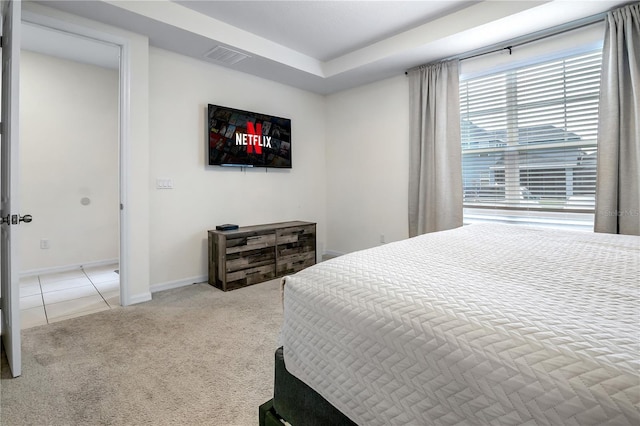 carpeted bedroom with tile patterned flooring, visible vents, and baseboards