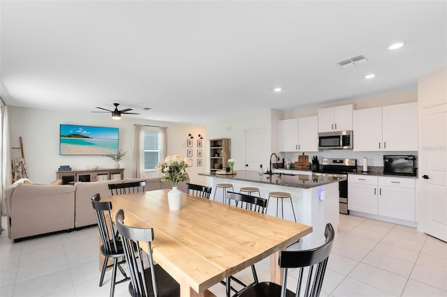 tiled dining space featuring sink and ceiling fan