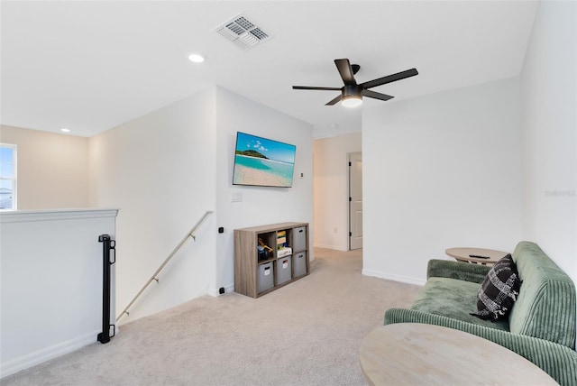 sitting room with ceiling fan and light colored carpet