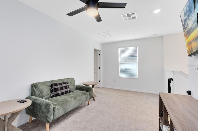 sitting room with ceiling fan and light colored carpet