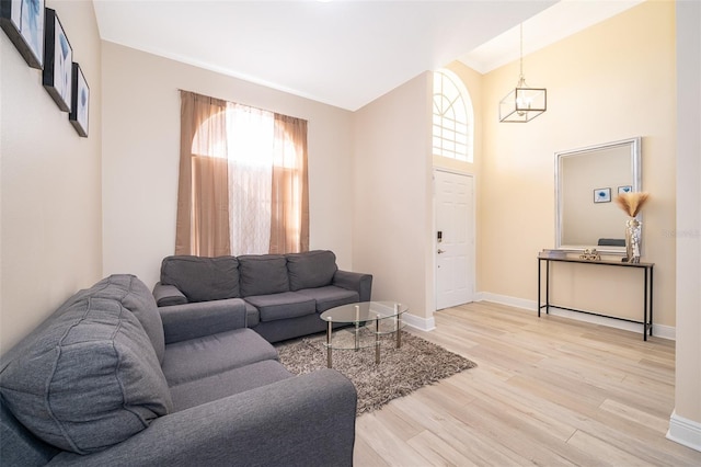 living room featuring high vaulted ceiling and light hardwood / wood-style floors