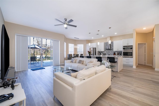 living room with ceiling fan and light hardwood / wood-style floors