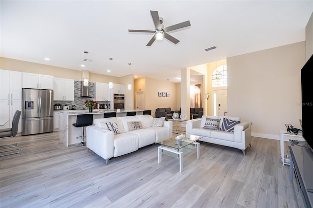 living room featuring ceiling fan and light wood-type flooring