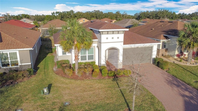 view of front of house with a garage, a residential view, decorative driveway, and stucco siding