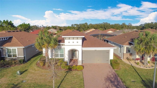 mediterranean / spanish home with a garage, a residential view, roof with shingles, decorative driveway, and stucco siding