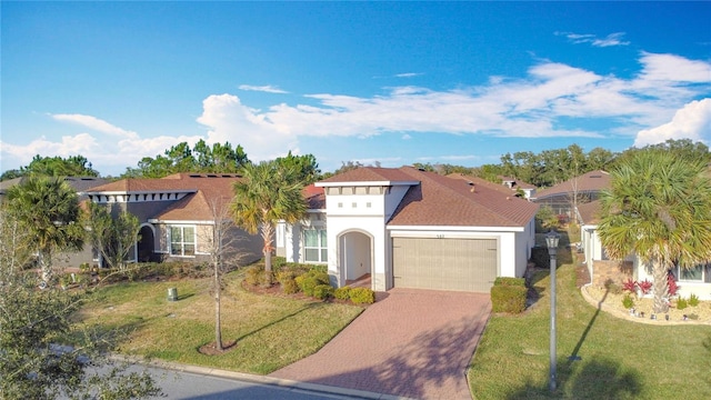 mediterranean / spanish house with a garage and a front lawn