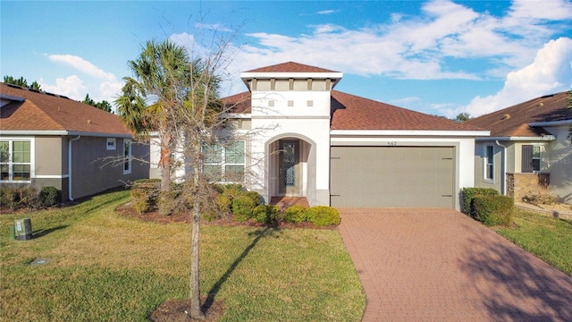 mediterranean / spanish-style house featuring a garage and a front yard