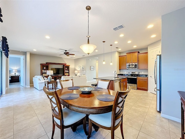 tiled dining room with sink and ceiling fan