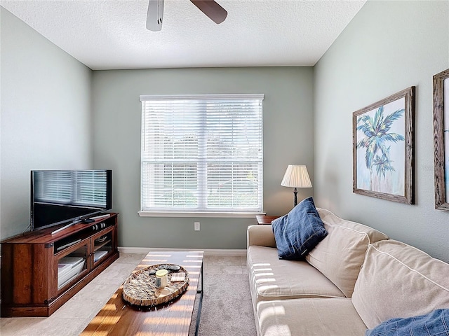 carpeted living room with ceiling fan, a wealth of natural light, and a textured ceiling