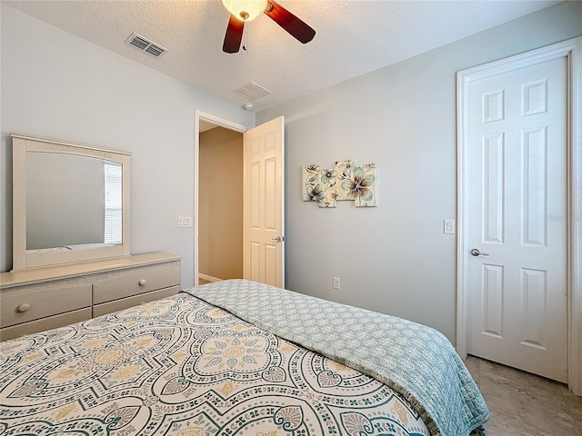 bedroom with ceiling fan and a textured ceiling