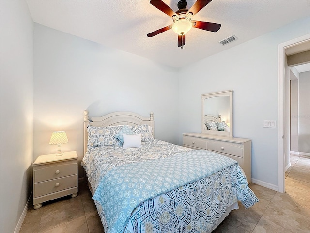 tiled bedroom featuring ceiling fan and a textured ceiling