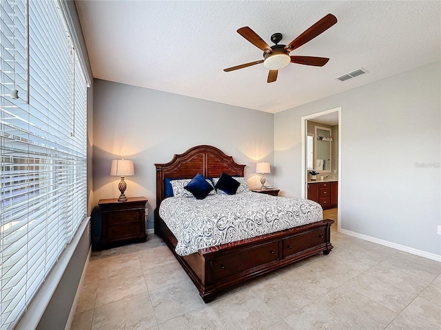 bedroom with connected bathroom, ceiling fan, and a textured ceiling