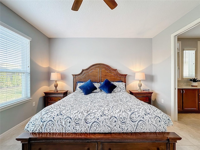 tiled bedroom with ceiling fan and a textured ceiling