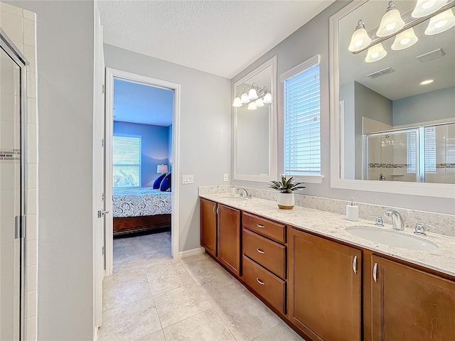 bathroom featuring vanity, a healthy amount of sunlight, a textured ceiling, tile patterned floors, and walk in shower