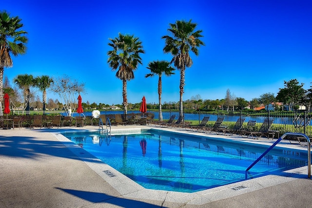 pool with a water view and fence