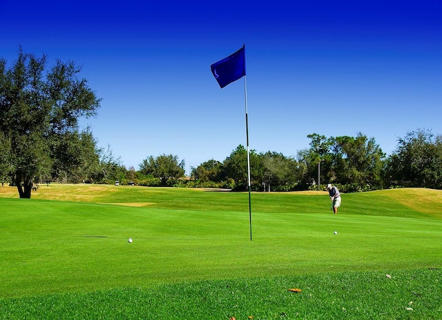 surrounding community with a lawn and golf course view