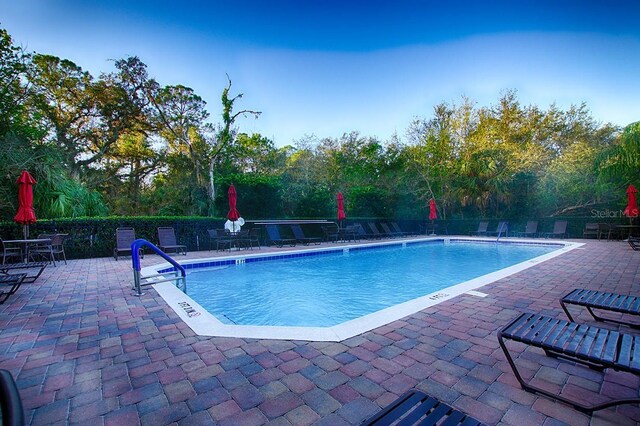 pool with a patio and fence