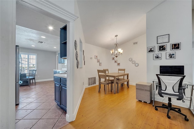 2417 Liela Lee Ct, Ocoee, FL 34761 - dining space with vaulted ceiling, light wood-type flooring, and an inviting chandelier