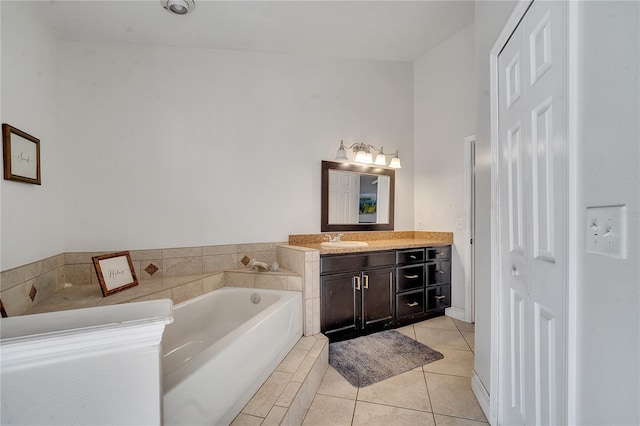 2417 Liela Lee Ct, Ocoee, FL 34761 - bathroom featuring vanity, a relaxing tiled tub, and tile patterned floors