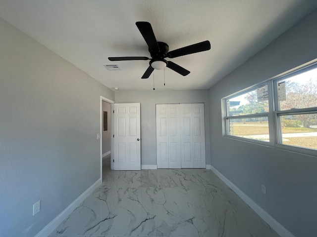 unfurnished bedroom with ceiling fan and a closet