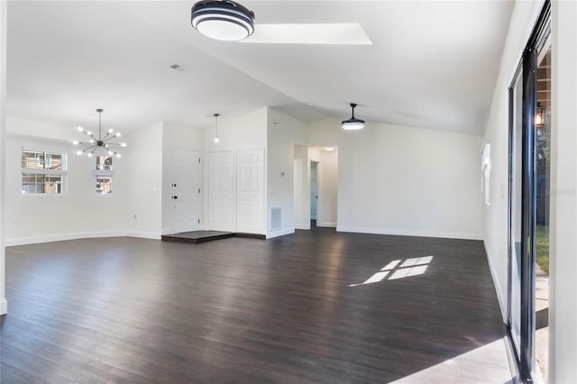 unfurnished living room with dark hardwood / wood-style flooring, lofted ceiling with skylight, and a chandelier