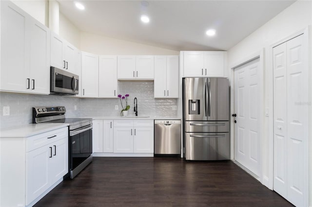 kitchen featuring white cabinetry, sink, stainless steel appliances, and lofted ceiling