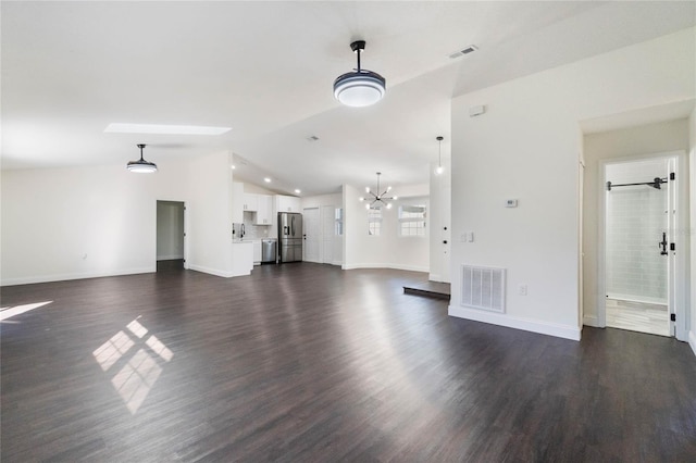 unfurnished living room featuring dark wood-type flooring, a chandelier, and vaulted ceiling