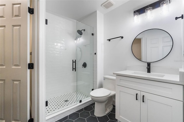 bathroom with vanity, a shower with shower door, tile patterned floors, and toilet