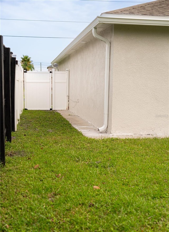 view of side of home with a yard