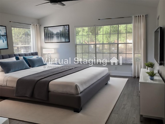 bedroom featuring dark hardwood / wood-style flooring, vaulted ceiling, and ceiling fan