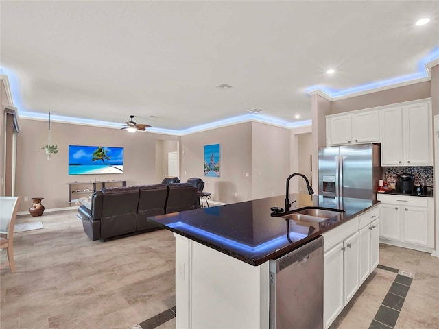 kitchen with decorative backsplash, dark countertops, appliances with stainless steel finishes, ornamental molding, and a sink