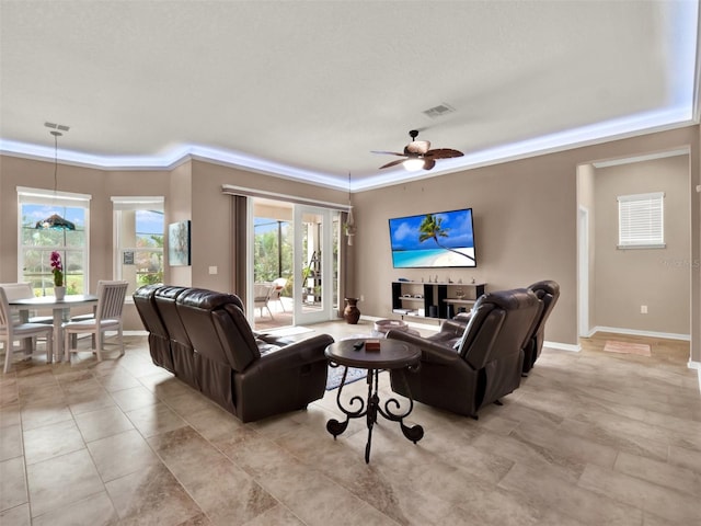 living area featuring visible vents, ceiling fan, and baseboards