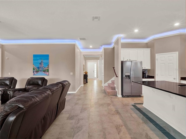 kitchen featuring visible vents, stainless steel fridge with ice dispenser, dark countertops, open floor plan, and white cabinetry