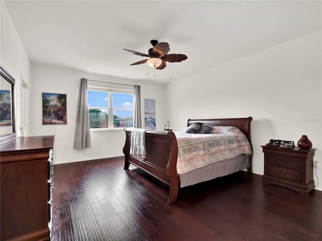 bedroom with ceiling fan, wood finished floors, and baseboards