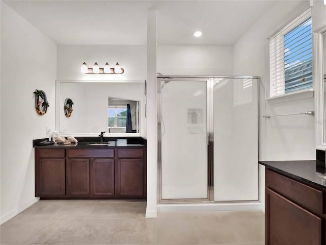 full bathroom with a stall shower, tile patterned flooring, and vanity