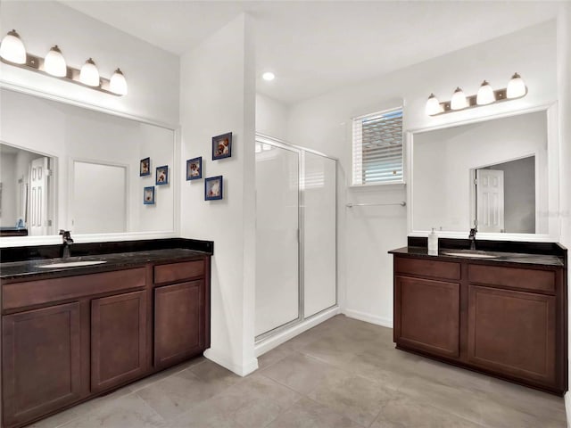 full bathroom featuring two vanities, a sink, and a shower stall