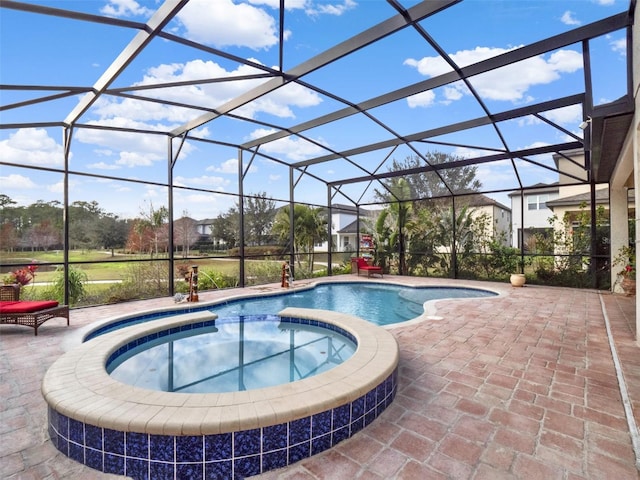 view of pool featuring a pool with connected hot tub, glass enclosure, and a patio