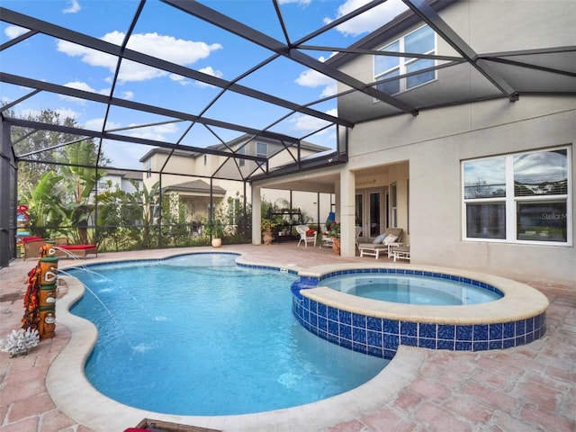 view of pool featuring a pool with connected hot tub, glass enclosure, a patio, and french doors