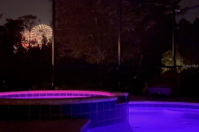 pool at twilight with a fenced in pool