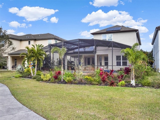 back of house with a yard, a lanai, and stucco siding