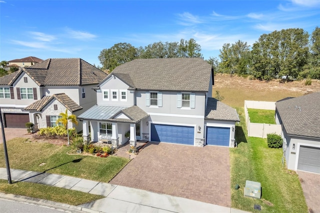 view of front of house with a garage, a front yard, and covered porch