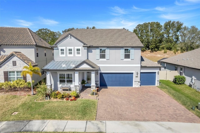 view of front of property with a garage, covered porch, and a front lawn