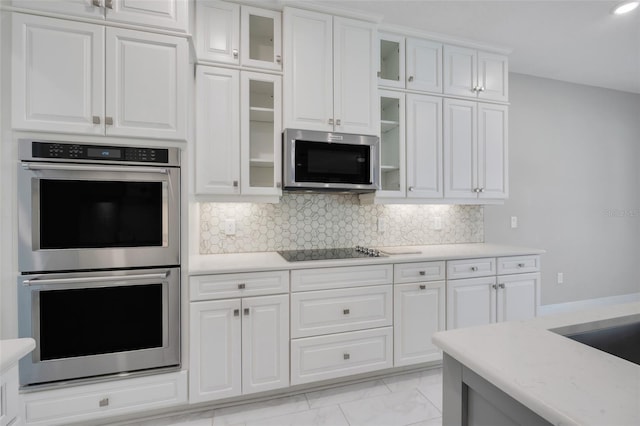 kitchen featuring tasteful backsplash, appliances with stainless steel finishes, and white cabinets