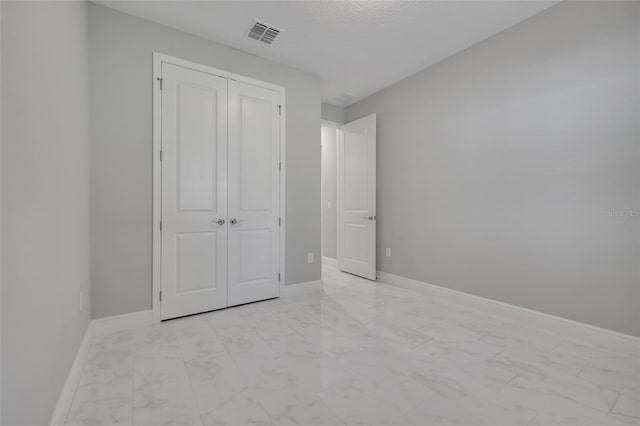 unfurnished bedroom featuring a closet and a textured ceiling